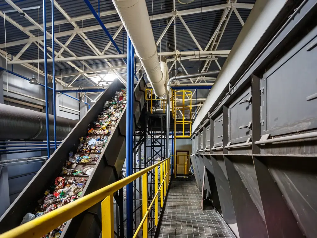 Ein Förderband aus der Recyclingindustrie, welches mit Abfall gefüllt ist