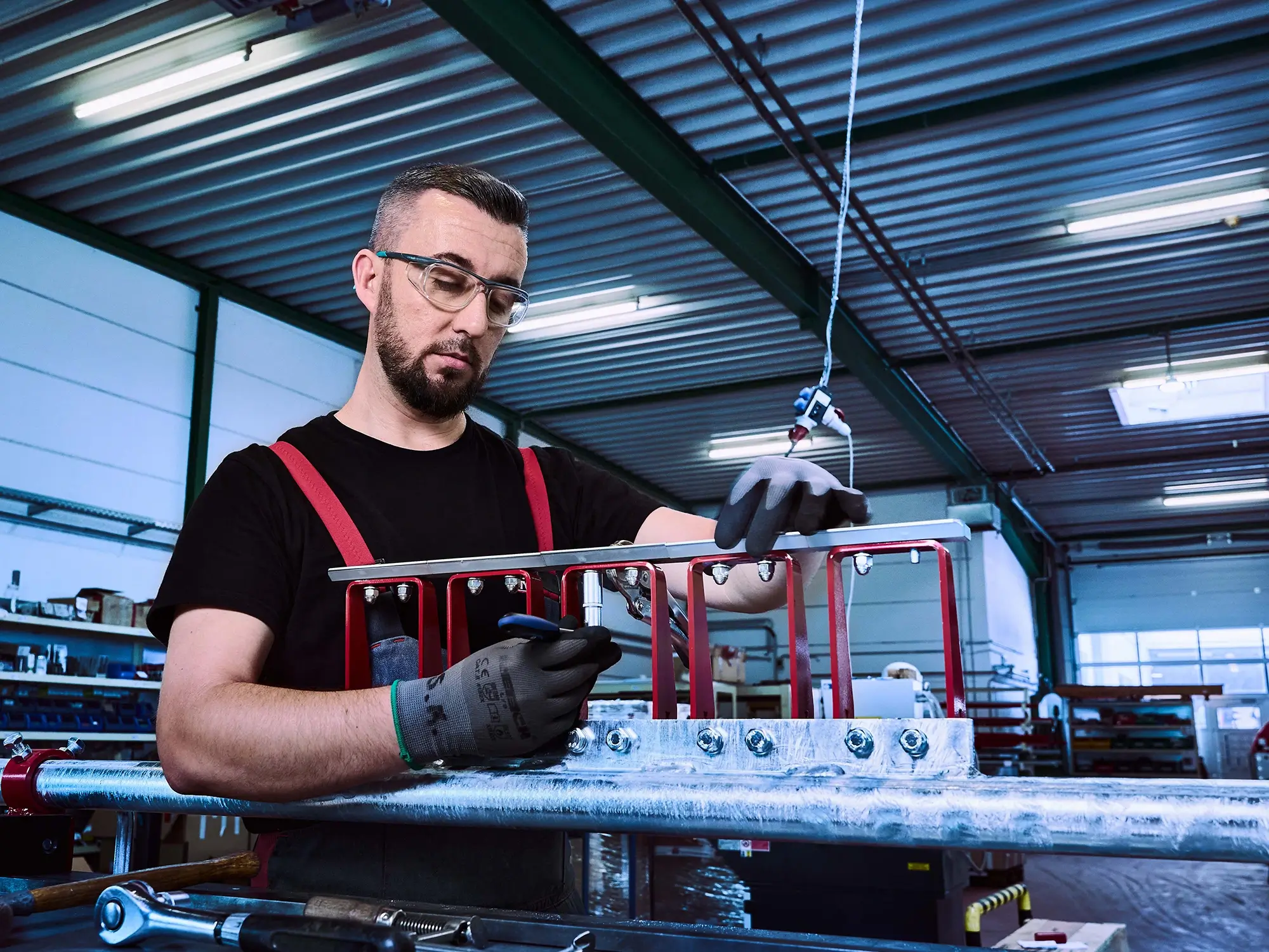 Ein Mitarbeiter bei der Überprüfung von Maßen einer technischen Konstruktion
