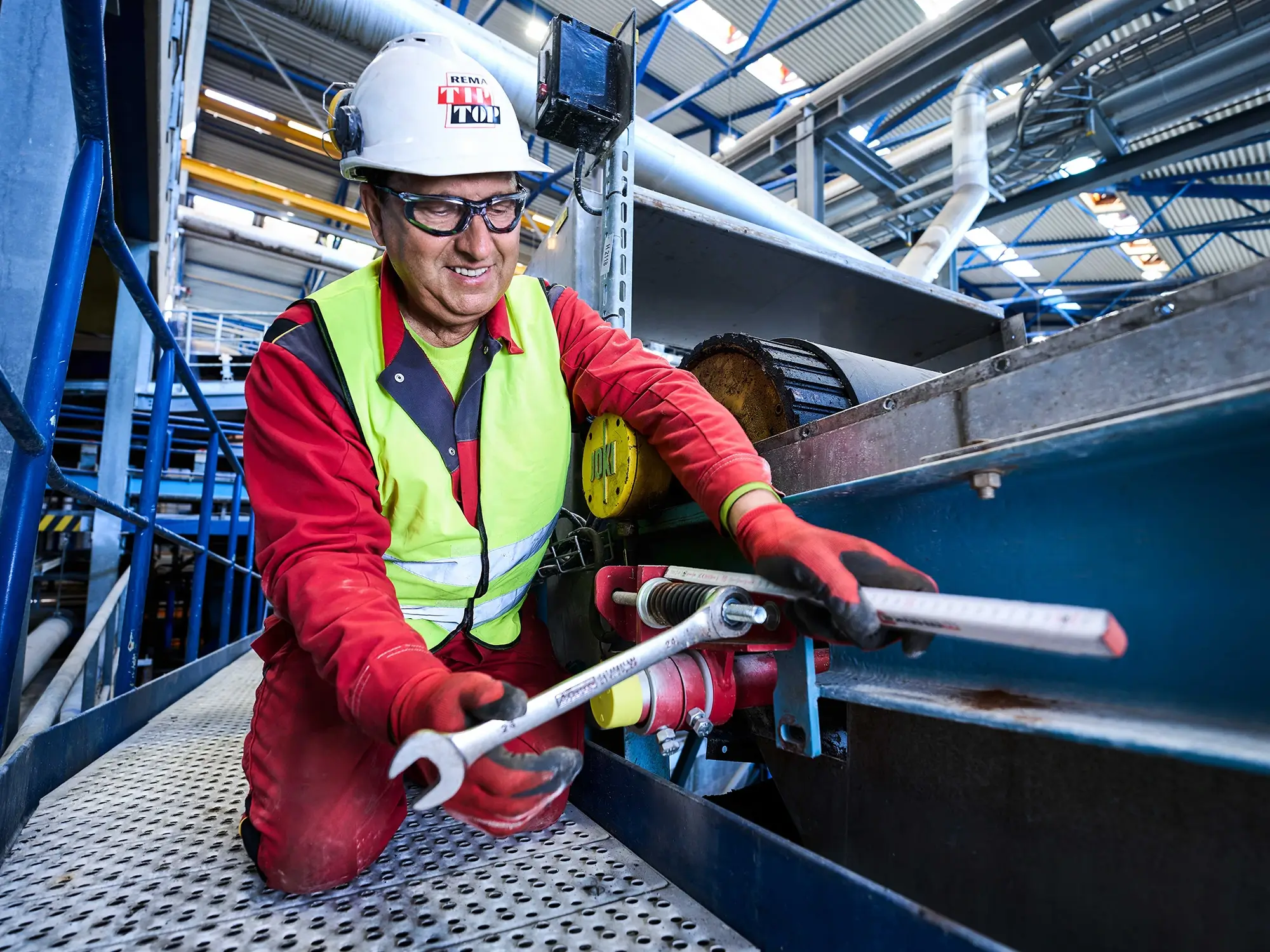 Eine Servicetechniker stellt ein Förderband korrekt ein