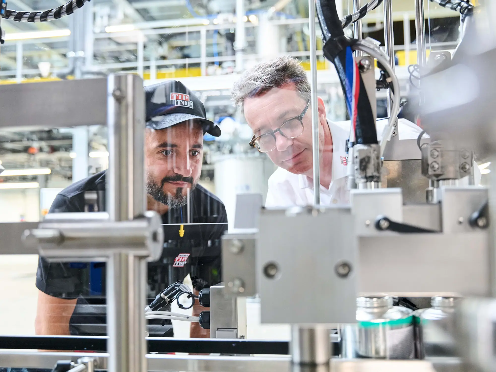 Zwei Mitarbeiter schauen sich den Produktionsvorgang der CEMENT SC 4000 Abfüllung an