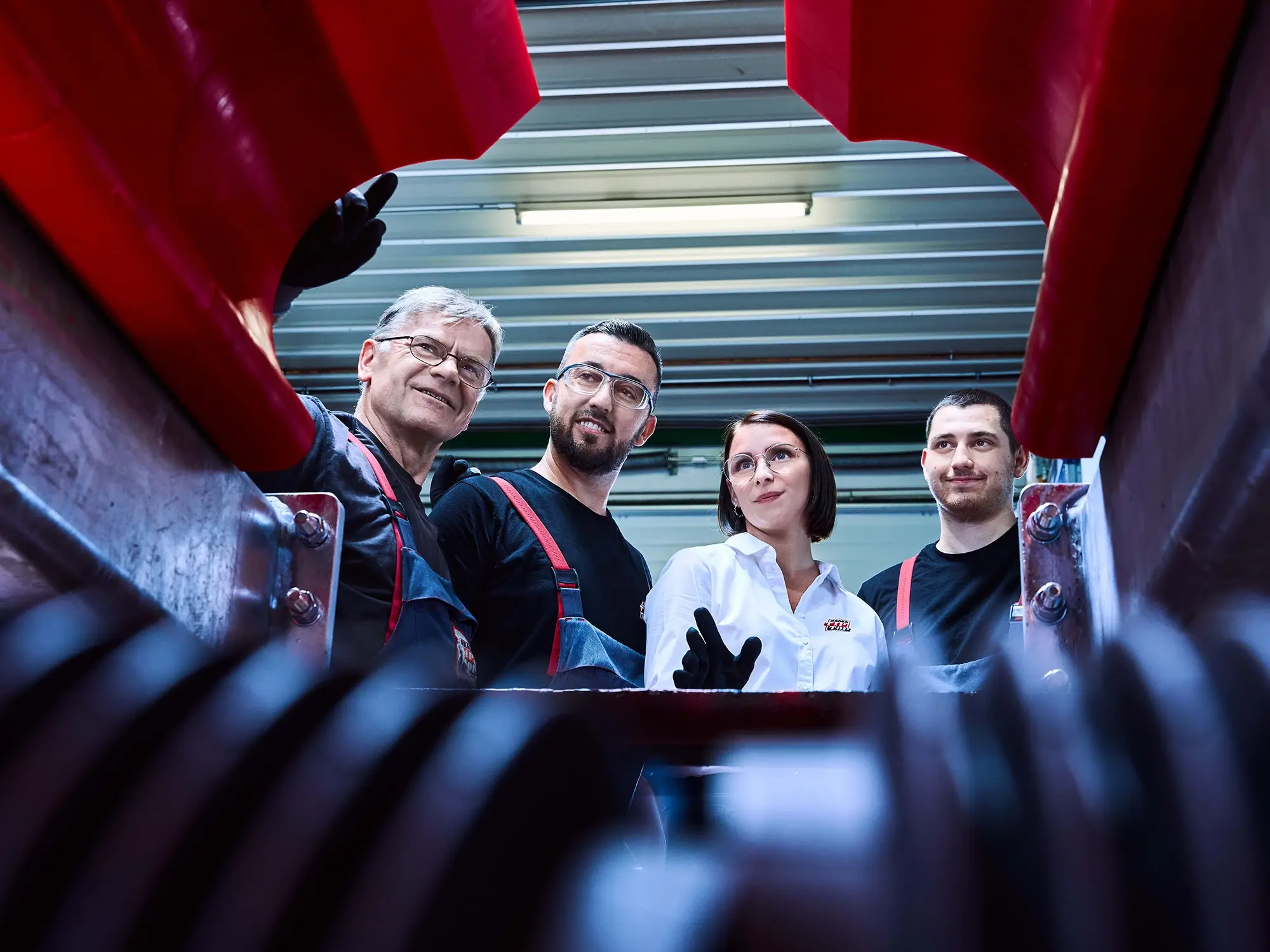 Vier Mitarbeiter begutachten eine Produktionsanlage