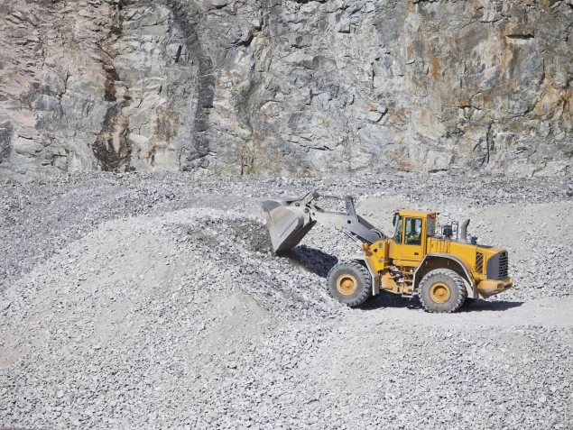 Ein Bagger in einer Mine, der Steine ablädt