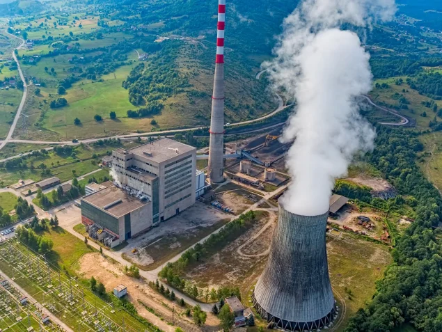 Luftaufnahme einer großen Industrieanlage mit Kühlturm und großem Schornstein