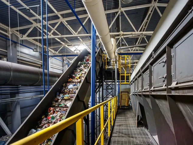 Ein Förderband aus der Recyclingindustrie, welches mit Abfall gefüllt ist