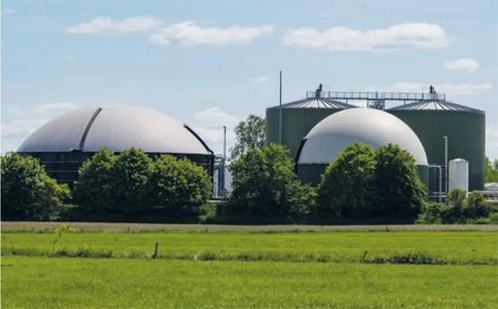 Biogas plant with green meadow in the foreground